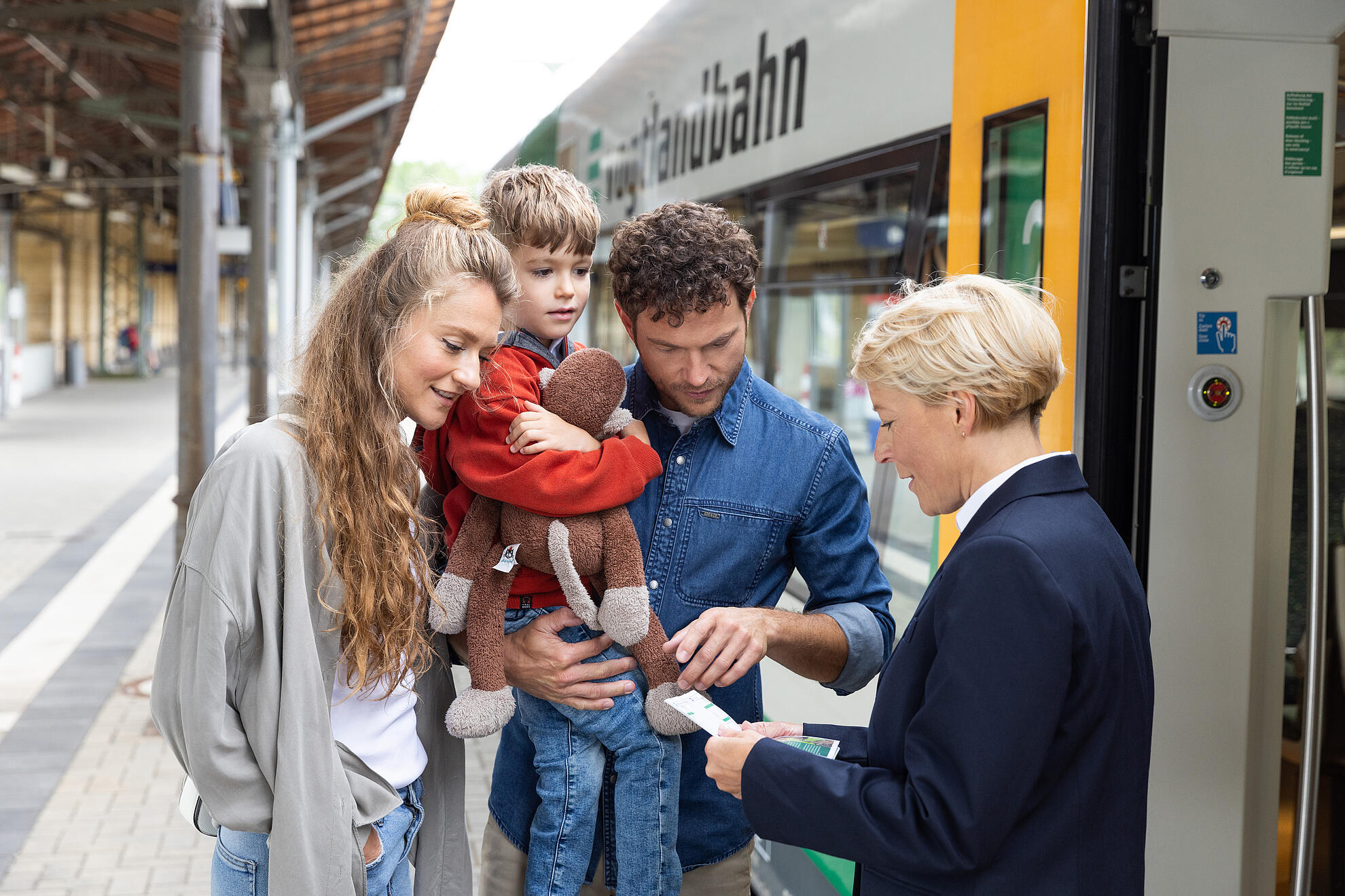Frau, Mann und Kind werden am Bahnsteig beraten