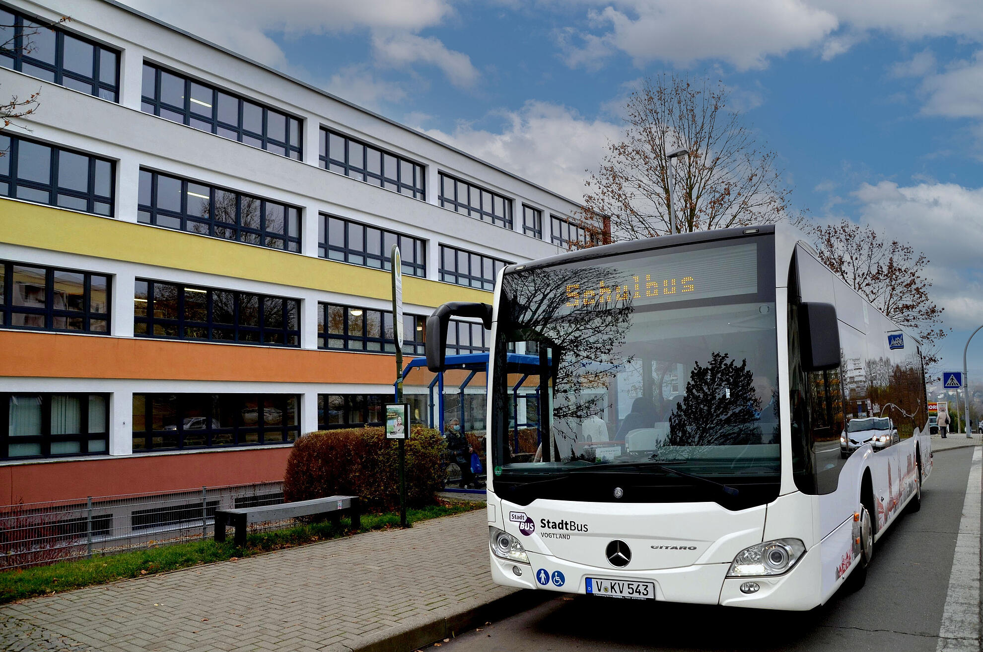 SchulBus hält vor einer Schule