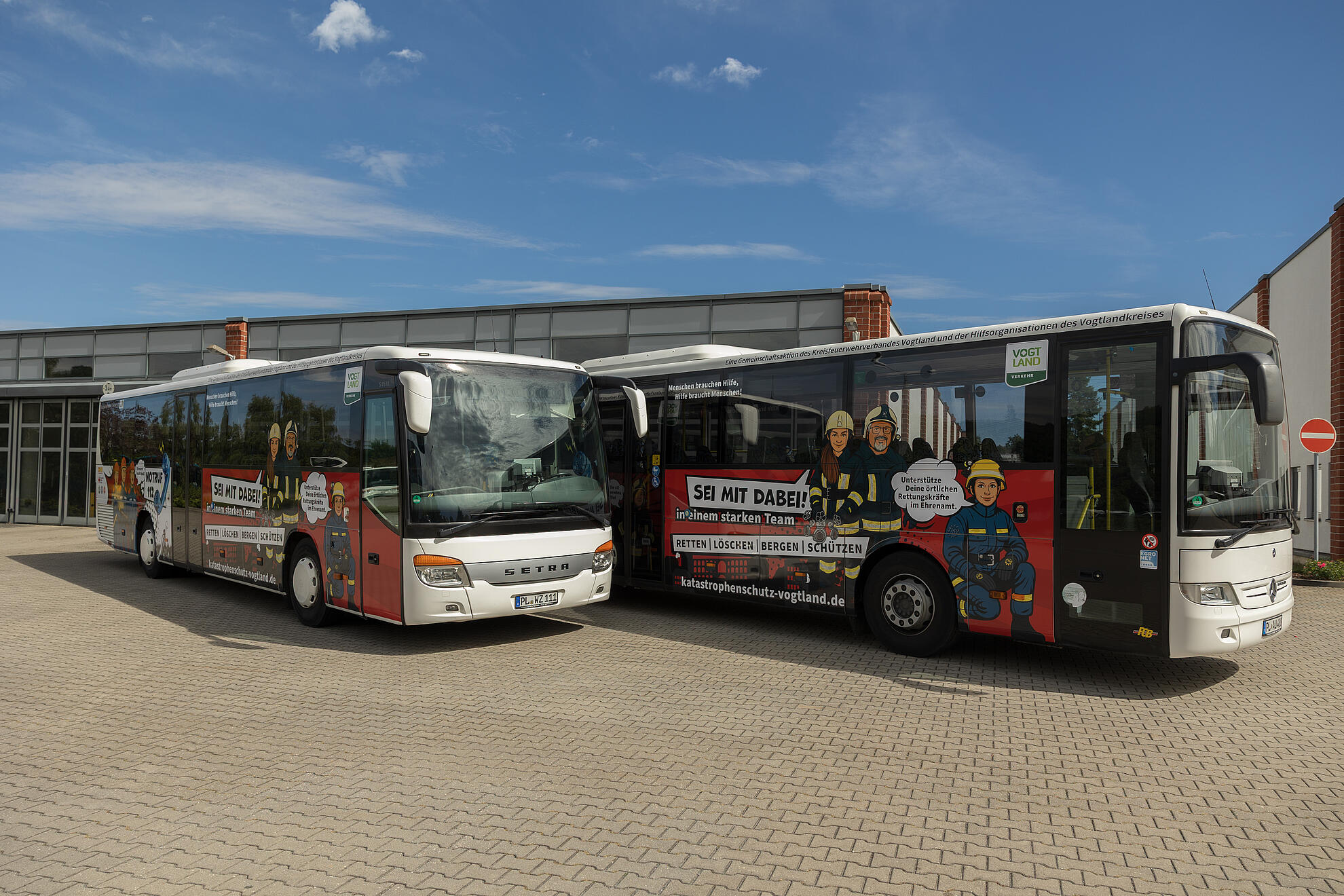 Zwei Schulbusse im neuen Look unterwegs für Hilfs- und Rettungskräfte