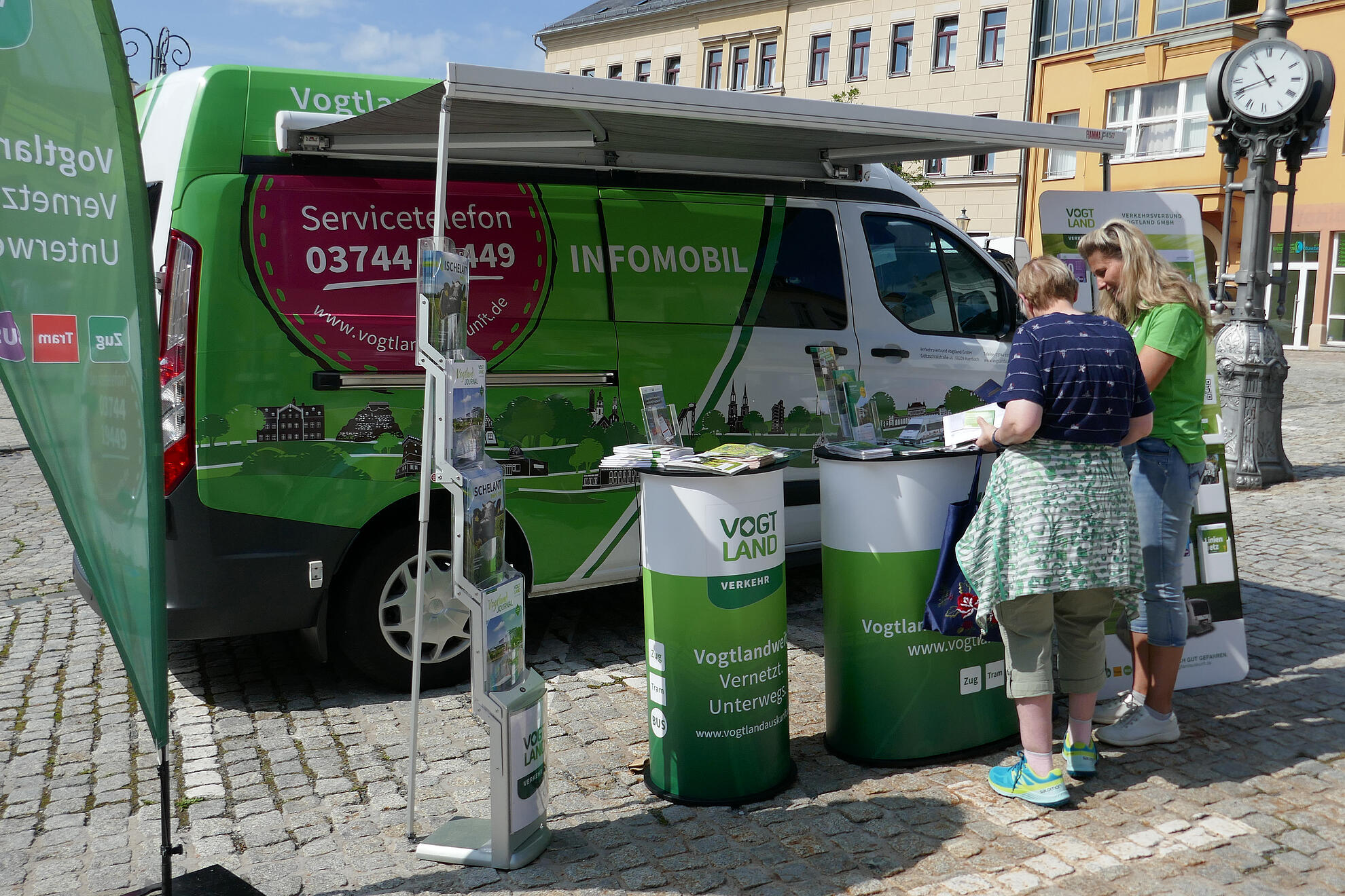 Mitarbeiter beraten Kunden vor dem Infomobil