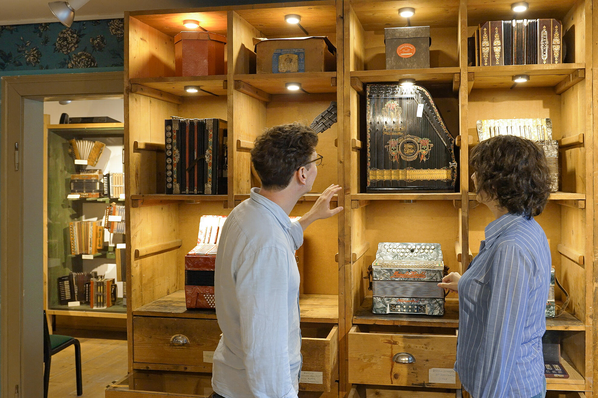 Zwei Personen begutachten die Ausstellung im Harmonikamuseum